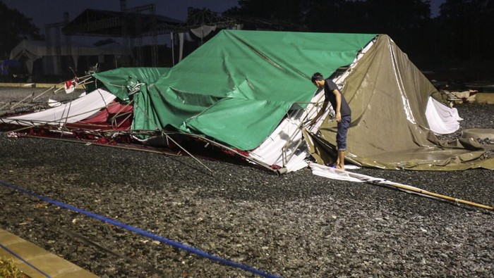 TENDA ACARA LEBARAN DEPOK ROBOH Pekerja melintas didepan tenda Lebaran Depok yang rusak dan roboh di Perumahan Shila, Depok, Jawa Barat, Kamis (2/6/2022). Hujan deras disertai angin kencang yang terjadi pada sore hari ini mengakibatkan sejumlah tenda bazar dan tenda acara Lebaran Depok roboh. Acara tersebut akan dilaksanakan pada tanggal 3 Juni 2022. ANTARA FOTO/Asprilla Dwi Adha/hp.