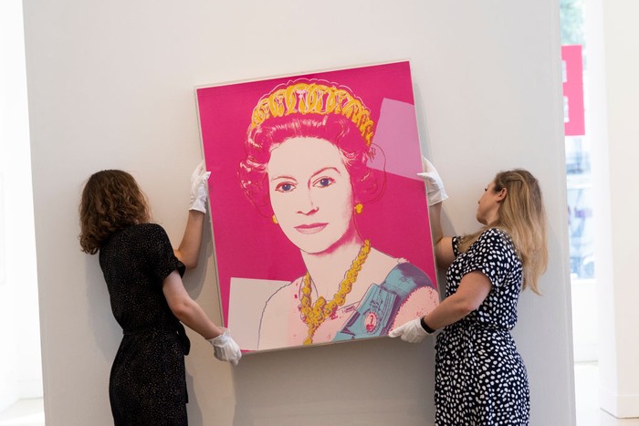 Wah! Lukisan Warhol tentang Ratu Elizabeth II Dilelang Rp 2,7 M LONDON, ENGLAND - JUNE 01: Gallery staff pose with a portrait of Queen Elizabeth II by artist Andy Warhol at Phillips auction house on June 01, 2022 in London, England. Phillips estimates the print to sell for Β£100,000 β 150,000 at auction, timed to coincide with the Queen's platinum jubilee. The portrait, part of Warhol's 1985