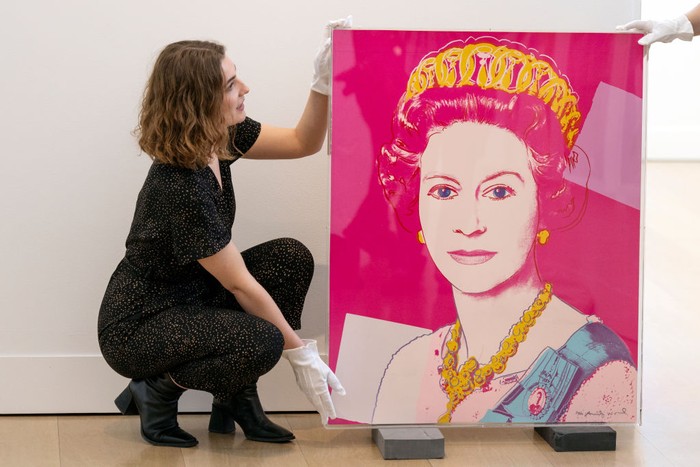 Wah! Lukisan Warhol tentang Ratu Elizabeth II Dilelang Rp 2,7 M LONDON, ENGLAND - JUNE 01: Gallery staff pose with a portrait of Queen Elizabeth II by artist Andy Warhol at Phillips auction house on June 01, 2022 in London, England. Phillips estimates the print to sell for Β£100,000 β 150,000 at auction, timed to coincide with the Queen's platinum jubilee. The portrait, part of Warhol's 1985