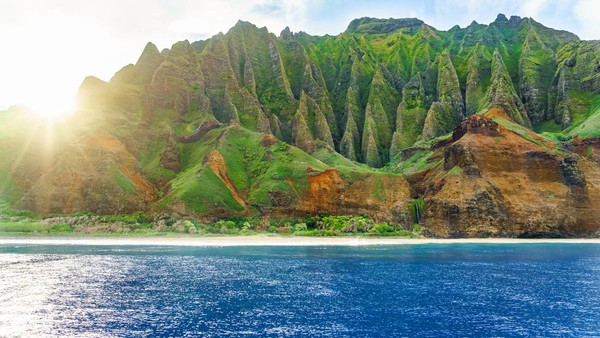 Pantai Na Pali di Kawai ditampilkan sebagai tempat di mana dinosaurus dibesarkan dan berkeliaran bebas. Di sini, wisatawan bisa naik perahu sewaan untuk lihat tebing yang tinggi atau tur nak helikopter. (Getty Images/iStockphoto)