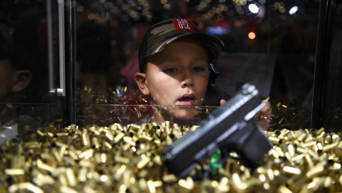 AS Kenalkan Senjata Api ke Anak-anak di Pameran Tahunan A child walks through a rifle exhibit as attendees try out the guns on display at the National Rifle Association (NRA) annual convention in Houston, Texas, U.S. May 28, 2022. REUTERS/Callaghan O'Hare