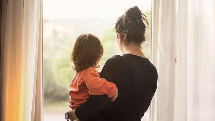 Mother and son looking out of window
