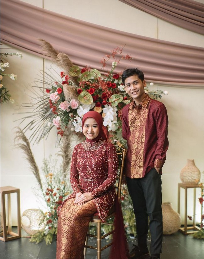 Dipenuhi dengan payet, kebaya lamaran hijab berwarna merah marun itu terlihat cantik dan elegan. Bagian depannya tampak memiliki belahan. Dipadukan dengan kain bawahan bermotif yang berwarna senada, penampilan Alca saat dilamar Bintang Emon jadi semakin memesona. Foto: Dok. Instagram @bintangemon.
