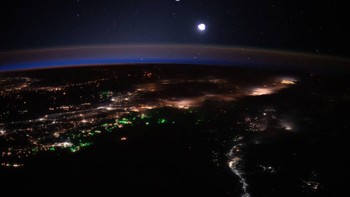 Kilauan matahari di Laut Timor antara Indonesia dan Australia disamarkan oleh tutupan awan dalam foto ini dari ISS. Foto: NASA