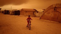 Seorang anak mengendarai sepeda di antara tenda-tenda kamp pengungsi di Provinsi Idlib, Suriah, Kamis (2/6/2022) waktu setempat. (Anas Alkharboutli/Getty Images)