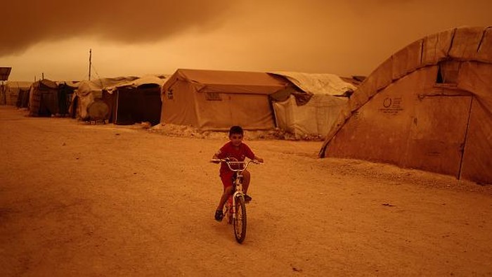 Nasib Anak-anak Pengungsi Suriah di Tengah Kepungan Badai Pasir 02 June 2022, Syria, Idlib City: Children play outside their tents at a camp for displaced people during a sandstorm hitting the Idlib Province. Photo: Anas Alkharboutli/dpa (Photo by Anas Alkharboutli/picture alliance via Getty Images)