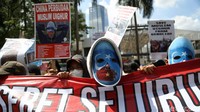 Tampak seorang demonstran mengenakan topeng berwarna biru dan merah saat ikut serta dalam aksi solidaritas untuk muslim Uighur di depan Kedubes China.