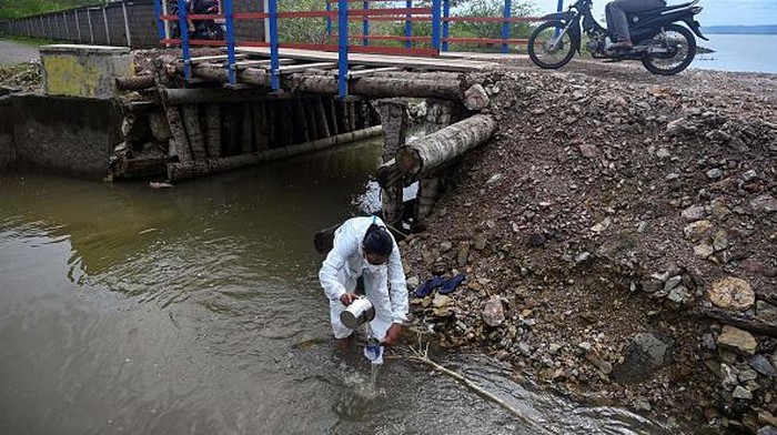 A volunteer checks water samples while conducting research on the amount of micro-plastics contained in the water at a beach in Pekan Bada, Indonesia's Aceh province on June 2, 2022. (Photo by CHAIDEER MAHYUDDIN / AFP) (Photo by CHAIDEER MAHYUDDIN/AFP via Getty Images)