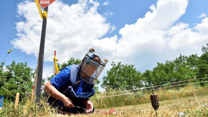 Warga Ukraina Berlatih Jinakkan Ranjau di Kosovo A trainer guides women who are part of a group of Ukrainians including civilians and army officers, as they are trained in the removal of landmines and other unexploded ordnances, amid Russia's invasion of Ukraine in Peja, Kosovo, May 31, 2022. Picture taken May 31, 2022. REUTERS/Laura Hasani