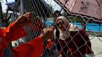 Sebagian penonton mengikatkan gagang payung di pagar JIEC.
