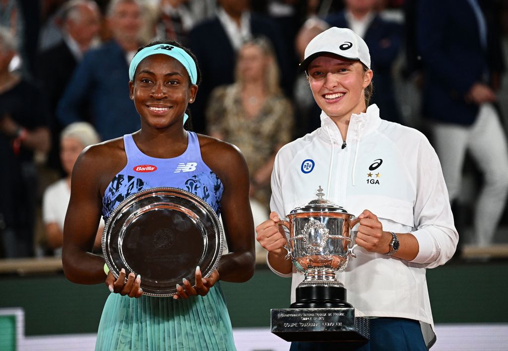 Poland's Iga Swiatek (R) and US' Coco Gauff (L) pose with their trophy at the end of their women's single final match on day fourteen of the Roland-Garros Open tennis tournament at the Court Philippe-Chatrier in Paris on June 4, 2022. - Iga Swiatek cruised to her second French Open title by dominating teenager Coco Gauff in the final as the world number one claimed her 35th successive victory. (Photo by Anne-Christine POUJOULAT / AFP) (Photo by ANNE-CHRISTINE POUJOULAT/AFP via Getty Images)