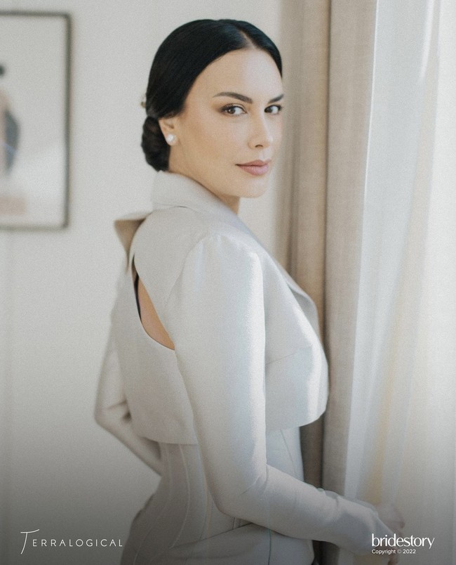 Potongan atas gaunnya terlihat seperti korset dengan aksen drapery khas Hian Tjen. Sophia juga memakai blazer yang memiliki aksen cut out di bagian belakang, membuat penampilannya terlihat seksi. Foto: dok. Instagram @thebridestory