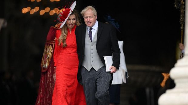 Perdana Menteri Inggris Boris Johnson (kanan) dan istrinya Carrie Johnson pergi setelah menghadiri Layanan Nasional Thanksgiving untuk pemerintahan Ratu di Katedral Saint Paul di London. (AFP/DANIEL LEAL)