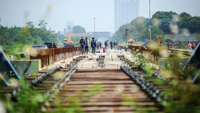 Pekerja menyelesaikan proyek rel ganda di Gedebage, Bandung, Jawa Barat, Sabtu (4/6/2022).  Proyek jalur ganda (double track) kereta api jalur Kiaracondong-Cicalengka tersebut ditargetkan rampung pada 2023 mendatang untuk mempercepat pelayanan penumpang, efektivitas waktu dan mampu melayani pengantaran barang hasil industri di kawasan itu. ANTARA FOTO/Raisan Al Farisi/nym.
