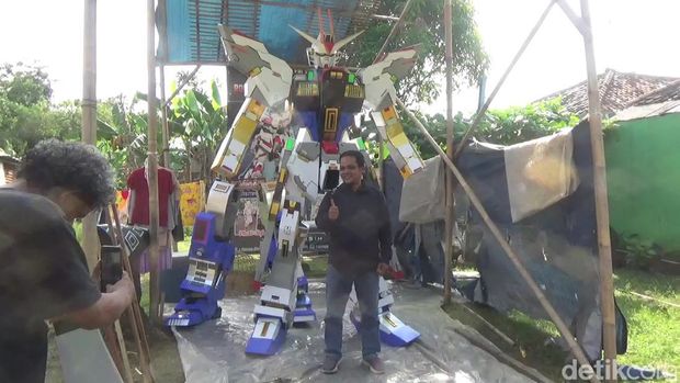 Warga berfoto dengan replika Gundam.