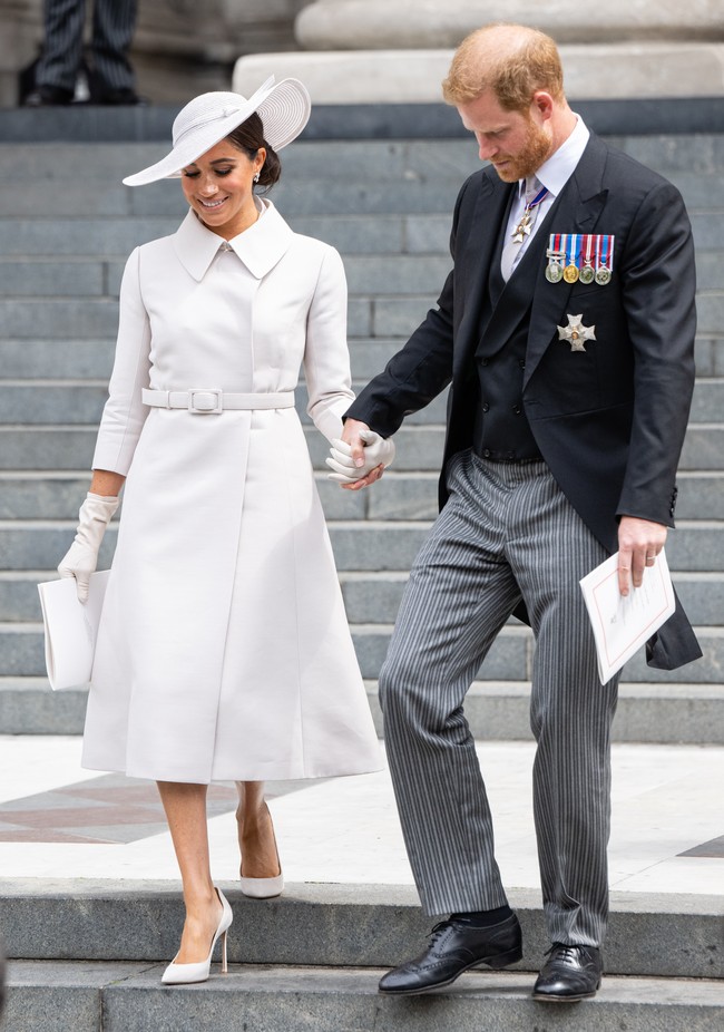 Menghadiri acara yang sama bersama Kate dan keluarga Kerajaan Inggris, Meghan Markle yang kali pertamanya muncul di acara kerajaan Inggris pasca-Megxit memilih tampilan yang lebih kalem dengan coat-dress putih Dior. Istri Pangeran Harry ini tampaknya ingin menghindari sorotan berlebih dengan memilih warna yang kerap dimaknai sebagai lambang kesucian dan awal yang baru itu. (Foto: WireImage/Samir Hussein)