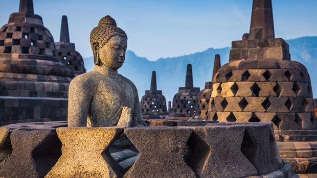 Ancient Buddha statue and stupa at Borobudur temple in Yogyakarta, Java, Indonesia.