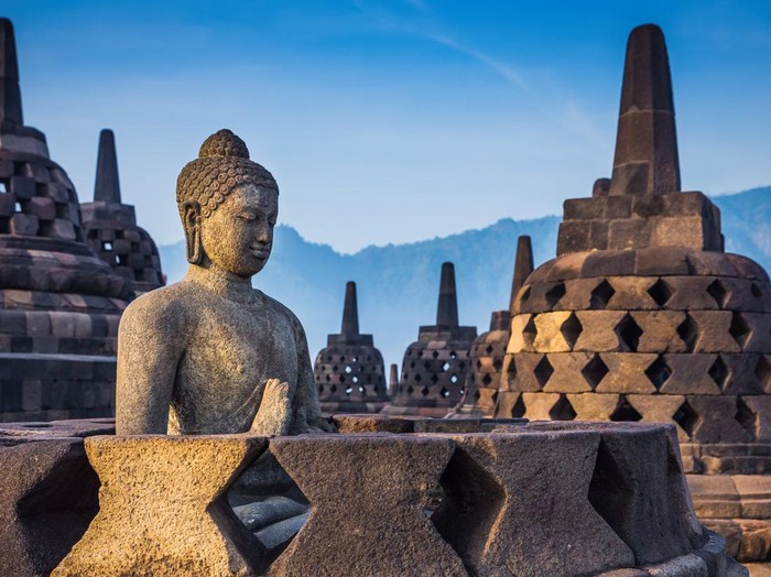 Ancient Buddha statue and stupa at Borobudur temple in Yogyakarta, Java, Indonesia.