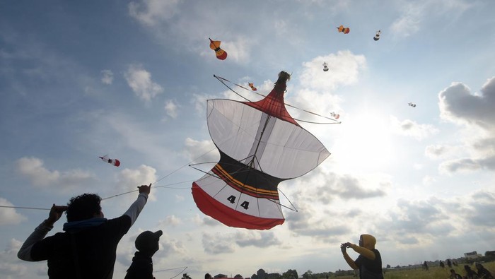 LOMBA LAYANG-LAYANG DI BALI Peserta menarik tali layang-layang saat mengikuti perlombaan dalam Dwi Tunggal Melesat Kite Festival di persawahan Nyalin, Desa Pedungan, Denpasar, Bali, Sabtu (4/6/2022). Kegiatan yang digelar untuk pelestarian permainan tradisional Bali tersebut kembali diselenggarakan setelah sempat ditiadakan selama dua tahun akibat pandemi COVID-19. ANTARA FOTO/Nyoman Hendra Wibowo/tom.
