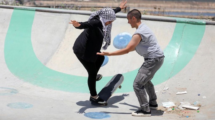 Italian activists train Young Palestinian girls to ride skateboards  in a new skatepark in the northern Gaza Strip, on June 5, 2022. The Green Hopes project is working to bring girls and women into skating in Gaza, where girls are often not allowed to play sports in public areas.
 (Photo by Majdi Fathi/NurPhoto via Getty Images)