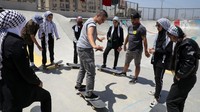 Ini momen saat para aktivis dari Italia mengajarkan cara bermain skateboard di kawasan Jalur Gaza Utara, Palestina, Minggu (5/6/2022).