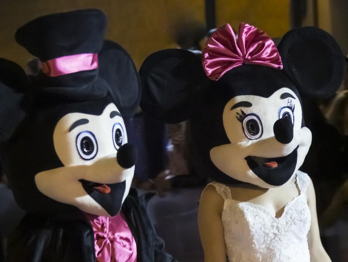 1306357002 Vila do Conde, Portugal - July 10, 2016: Accessories and entertainment promotion parade for events and weddings. Couple featured in Mickey and Minnie with wedding dresses