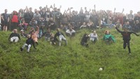 Ini dia penampakan sejumlah peserta lomba yang berpartisipasi dalam Cheese Rolling Festival di Gloucester, Inggris, Minggu (5/6/2022).