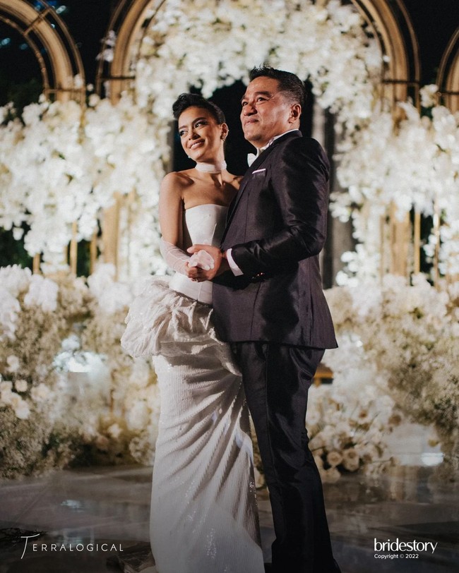 Dekorasi untuk resepsi yang digelar di Hotel The Langham pun bernuansa serba putih. Kesan mewah terpancar lewat kubah emas sebagai ‘kerangka’ rangkaian bunga. Foto: Instagram @thebridestory