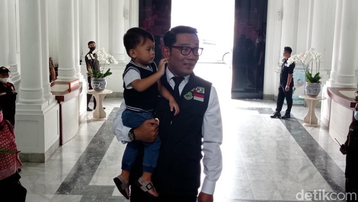 Gubernur Jabar Ridwan Kamil menggendong anak bungsunya Arkana Aidan Misbach, saat hari pertama kerja usai menjalani cuti
