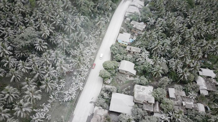 Gunung Bulusan Filipina Erupsi, Rumah dan Jalan Tertutup Abu TOPSHOT - Provincial Disaster Risk Reduction Management officers guide vehicles passing through the highway of Juban town, Sorsogon Province, after the sudden eruption of Bulusan Volcano on June 5, 2022. (Photo by SHARBYN SAYAT / AFP) (Photo by SHARBYN SAYAT/AFP via Getty Images)