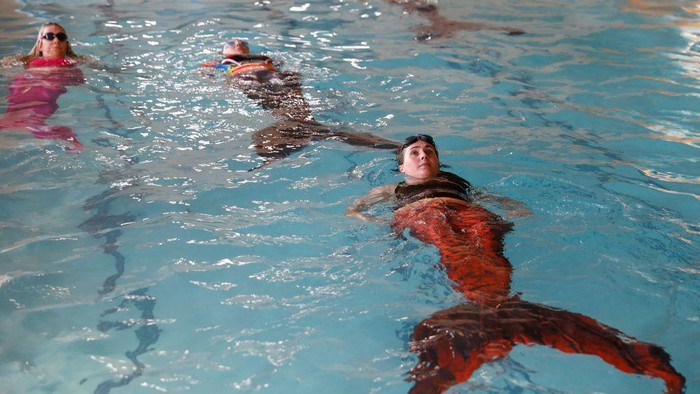 Melihat Sekolah Putri Duyung di Afrika Selatan Students perform a routine during their mermaiding class at the Merschool in Kayalami, near Midrand, on June 3, 2022. - Mermaiding is a fast growing sport world wide and includes several skills such as monofin swimming, sculling, tricks and breath hold. (Photo by Phill Magakoe / AFP) (Photo by PHILL MAGAKOE/AFP via Getty Images)