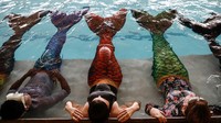 Sebelum memulai latihan para siswa melakukan pemanasan di pinggir kolam renang dengan menggunakan kostum putri duyung.  