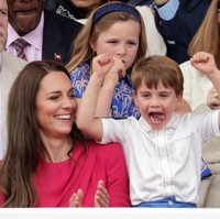 Anak bungsu Pangeran William dan Kate Middleton ini mengenakan kemeja putih dengan list biru yang dipadu celana pendek biru muda. Tampak dudu di sampingnya, Kate Middleton yang tampil cerah mengenakan gaun warna magenta. Foto: Getty Images