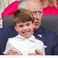 Berada di pangkuan kakek, Pangeran Charles, Pangeran Louis tampak tertawa senang. Foto: Getty Images