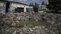 Kini kawah bekas hantaman rudal di sekitar pasar di kota Soledar, Donbas, telah tergenang oleh air. (AFP/Aris Messinis).
