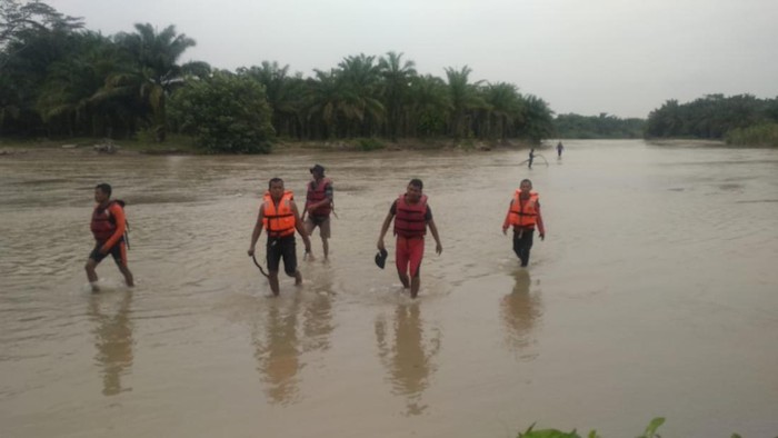 Petugas saat menyusuri sungai mencari warga yang hilang