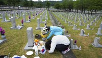 Lee Myung-ja dan Lee Young-sook (bawah), membungkuk di depan nisan saudara mereka Lee Sun-woo yang meninggal selama Perang Korea. AP/Ahn Young-joon