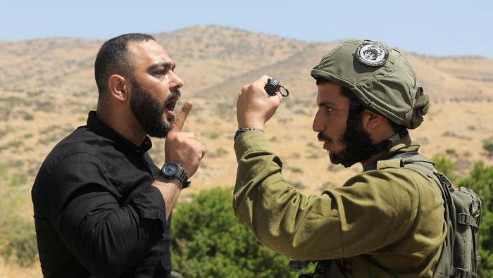 Saat Warga Palestina Adu Argumen dengan Tentara Israel An Israeli soldier argues with a Palestinian demonstrator during a protest against Israeli settlements in Jordan Valley in the Israeli-occupied West Bank June 6, 2022. REUTERS/Raneen Sawafta