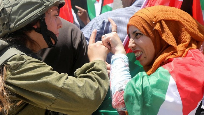 Saat Warga Palestina Adu Argumen dengan Tentara Israel An Israeli soldier argues with a Palestinian demonstrator during a protest against Israeli settlements in Jordan Valley in the Israeli-occupied West Bank June 6, 2022. REUTERS/Raneen Sawafta