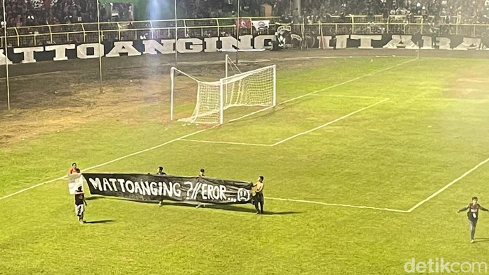 Suporter PSM Makassar membentangkan spanduk sindiran terkait Stadion Mattoanging yang terbengkalai.