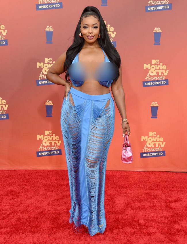 Detail fringe yang mendominasi bawahan Chasity Saunders ini membuatnya seperti gorden berjalan di karpet merah. Gaya busananya makin jauh dari kesan stylish dengan kekontrasan warna baju dan tas. (Foto: Gregg DeGuire/FilmMagic)