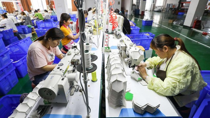 ZUNYI, CHINA - JUNE 06: Employees make footballs at a factory on June 6, 2022 in Zunyi, Guizhou Province of China. (Photo by Qu Honglun/China News Service via Getty Images)