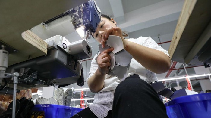 ZUNYI, CHINA - JUNE 06: Employees make footballs at a factory on June 6, 2022 in Zunyi, Guizhou Province of China. (Photo by Qu Honglun/China News Service via Getty Images)
