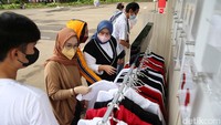 Pengunjung tampak tengah memilih kaos di Booth Official Merchandise PBSI.