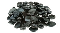 Camilan berwarna hitam seperti batu ini ternyata permen yang dikenal dengan rasanya yang super asin. Foto: firstwefeast.com