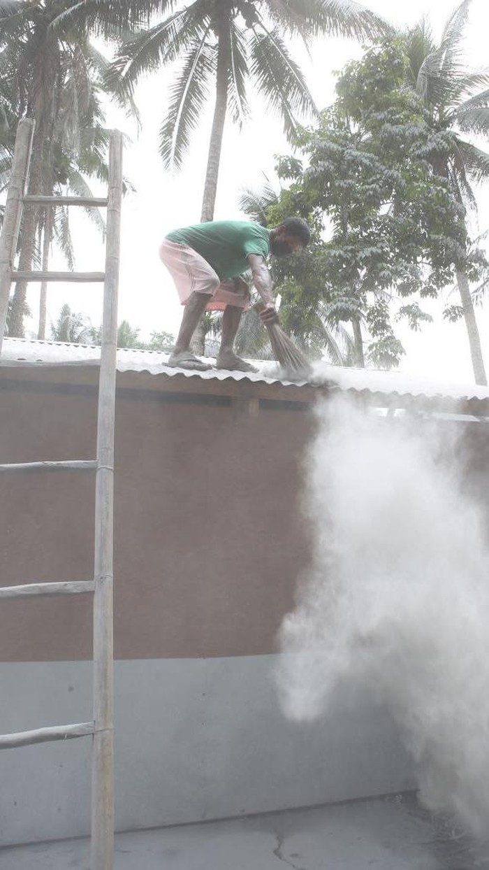 Coast guard personnel shovel ash to clear a road in Juban town, Sorsogon province on June 6, 2022, a day after the eruption of Bulusan volcano. - The volcano in the eastern Philippines spewed a huge, dark cloud on June 5, prompting evacuations from ash-covered towns while authorities warned of possible further eruptions. (Photo by Charism SAYAT / AFP) (Photo by CHARISM SAYAT/AFP via Getty Images)