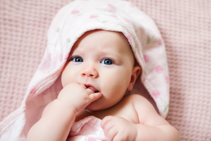 ilustrasi bayi Authentic portrait of 4 months baby girl wrapped in hooded towel after bath. Horizontal image in soft pink tones.