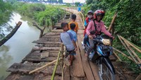 Warga melintasi akses jembatan yang rusak penghubung antara kecamatan Jonggol dan kecamatan Klapanunggal di Singasari, Jonggol, Kabupaten Bogor, Jawa Barat, Selasa (7/6/2022).