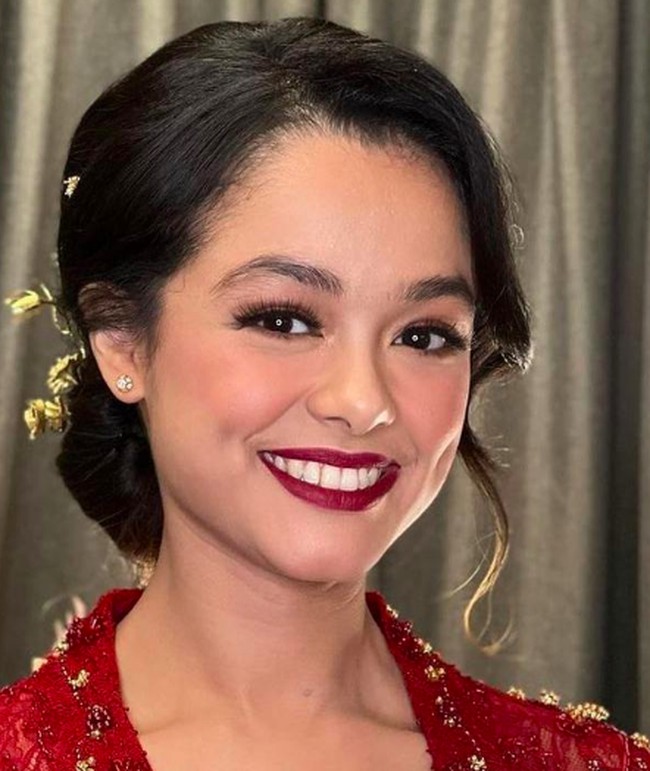 Menyesuaikan dengan warna kebayanya, Tia pun memilih makeup bold i acara lamarannya tersebut. Lipstik merah berry membuat penampilannya yang biasanya terlihat kasual jadi tampak manglingi. Foto: dok. Instagram/@naura_wedding