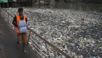 Seorang pria melintasi jembatan yang membentang di atas Sungai Negro yang dipenuhi sampah di Manaus, negara bagian Amazonas, Brasil, Senin (6/6/2022) waktu setempat.